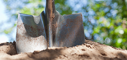 Use a rounded or blunt-edged shovel for safe hand-digging around utility lines.