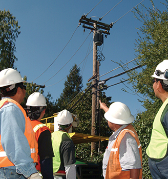 Workers surveying overhead power lines