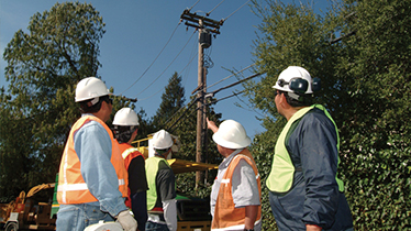 Workers pointing at overhead power line