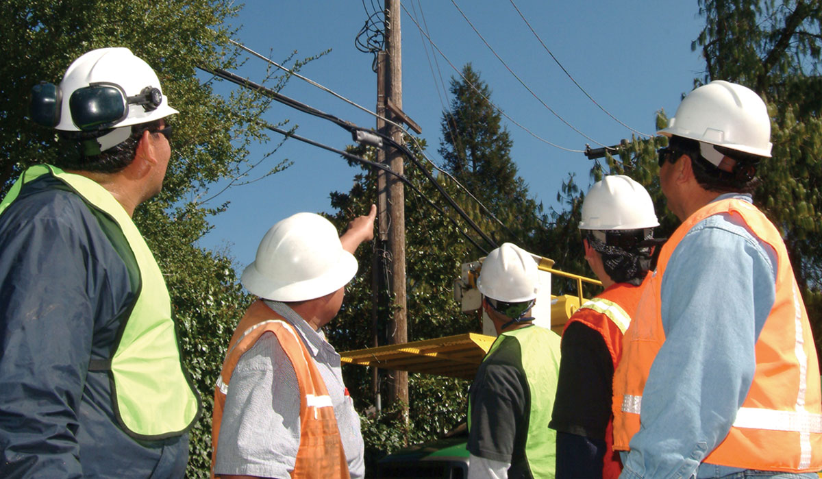 Workers pointing at overhead powerline