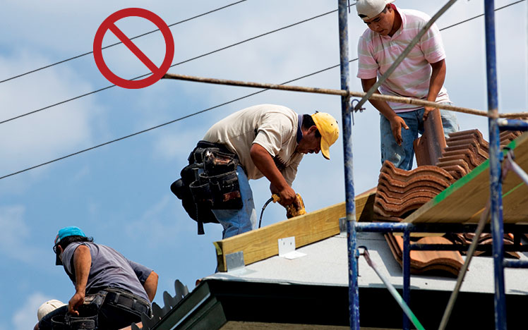 Workers on roof near overhead power lines